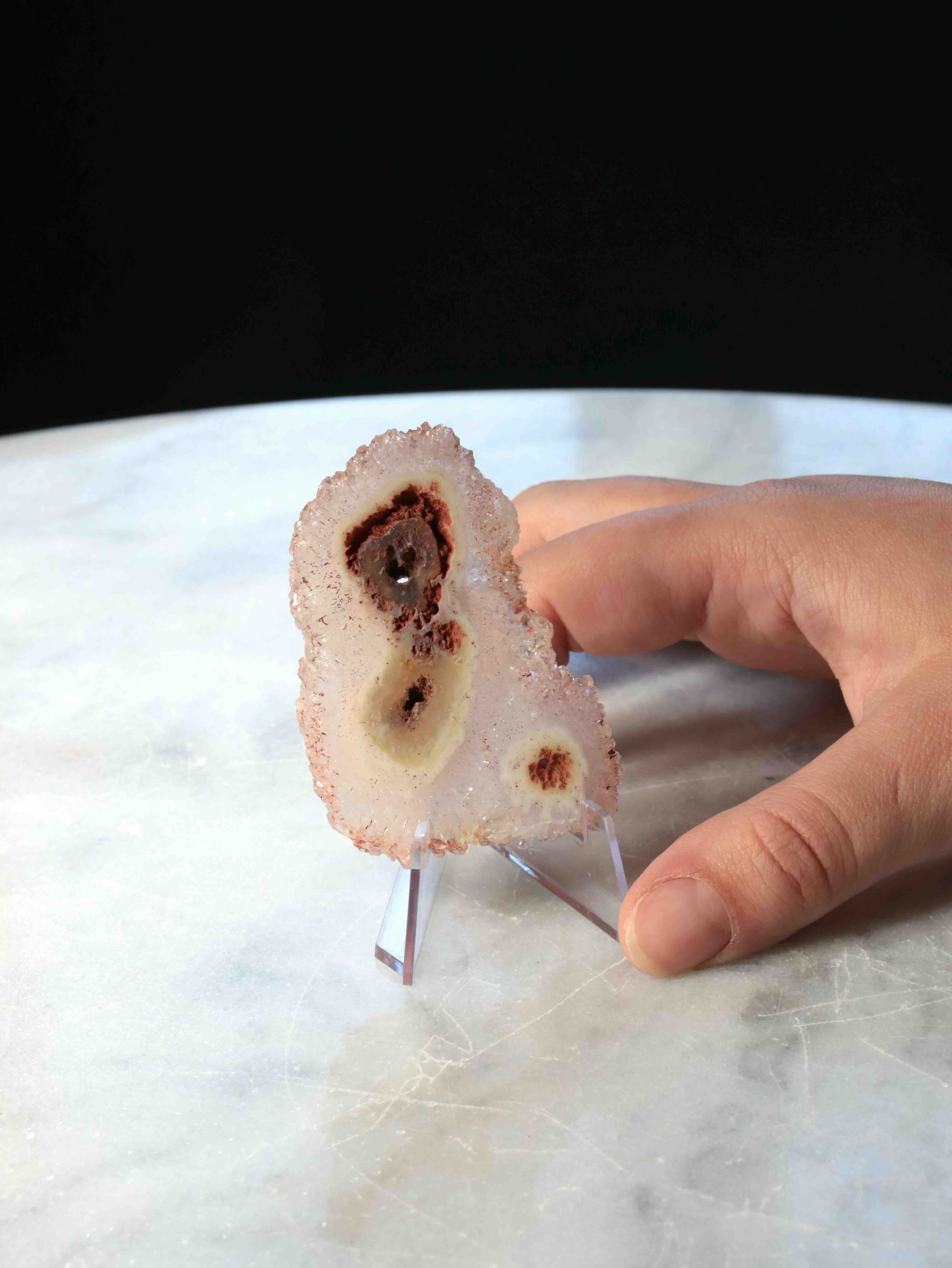 Fleur d'Agate naturelle tenue en main – motifs brun-rouille et druze cristallisée sur fond blanc rosé, taille réelle – pierre décorative éthique – SOLYA Belgique