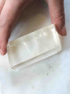 Pierre de Calcite Optique sculptée posée sur surface naturelle – cristal de clarté et de perspective, SOLYA