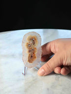 Fleur d'Agate naturelle tenue en main – motifs caramel et ambre avec druze scintillante, taille réelle – pierre décorative éthique Brésil – SOLYA Belgique