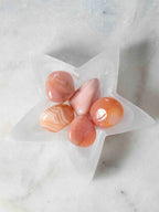Coupelle étoile en sélénite vue de dessus avec pierres roulées – cornaline et agate orange – purification cristaux SOLYA Belgique