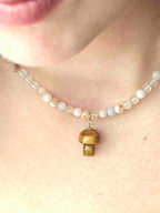 Charm champignon en Œil-de-Tigre suspendu à un collier de perles translucides — SOLYA