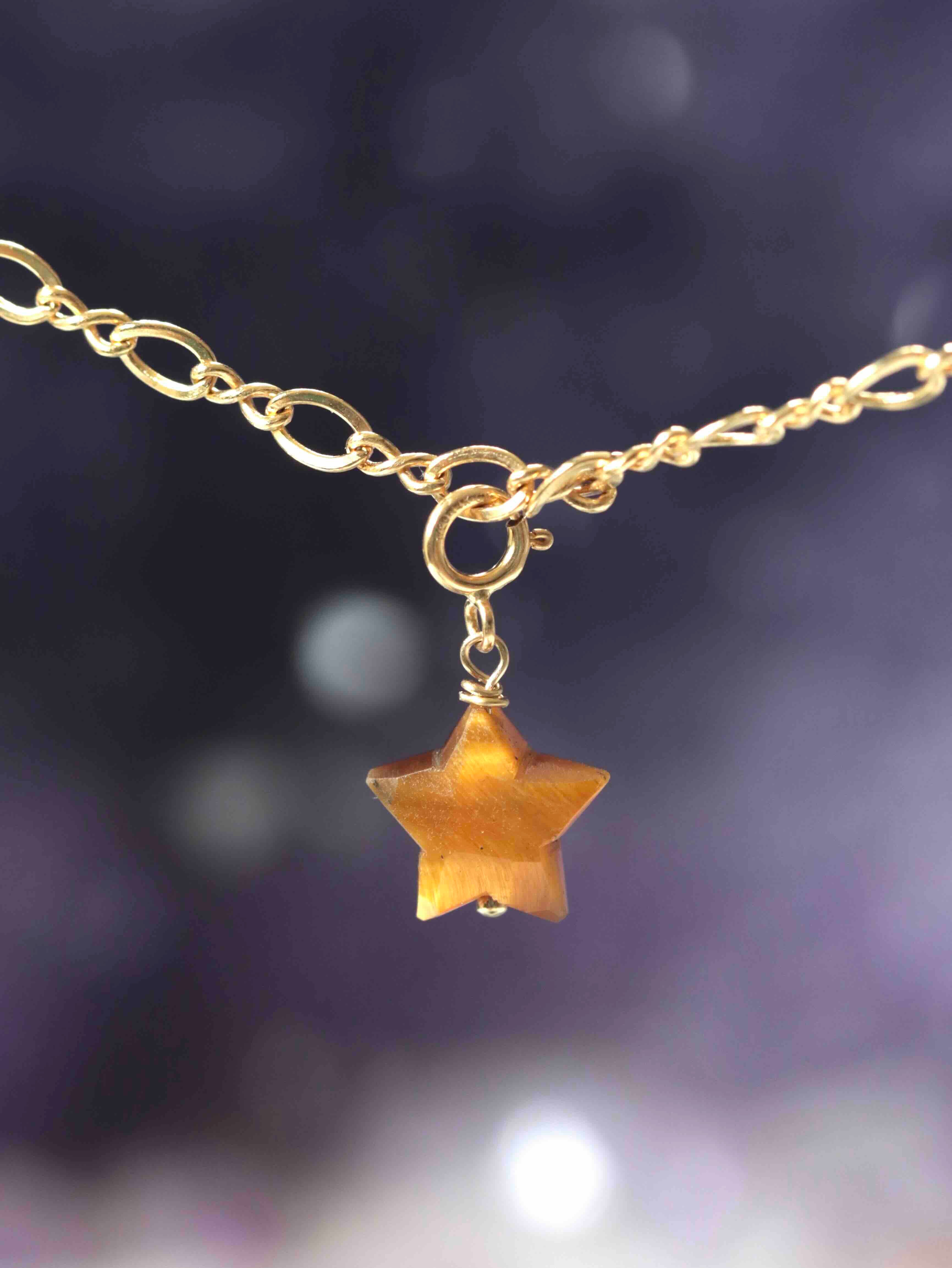 Charm étoile en Œil-de-Tigre taillé main suspendu à une chaîne Gold-filled 14K SOLYA — reflets dorés ambrés sur fond sombre