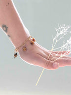 Bracelet à charms en Œil-de-Tigre et Gold-filled 14K porté au poignet — bijou SOLYA avec gemmes étoiles