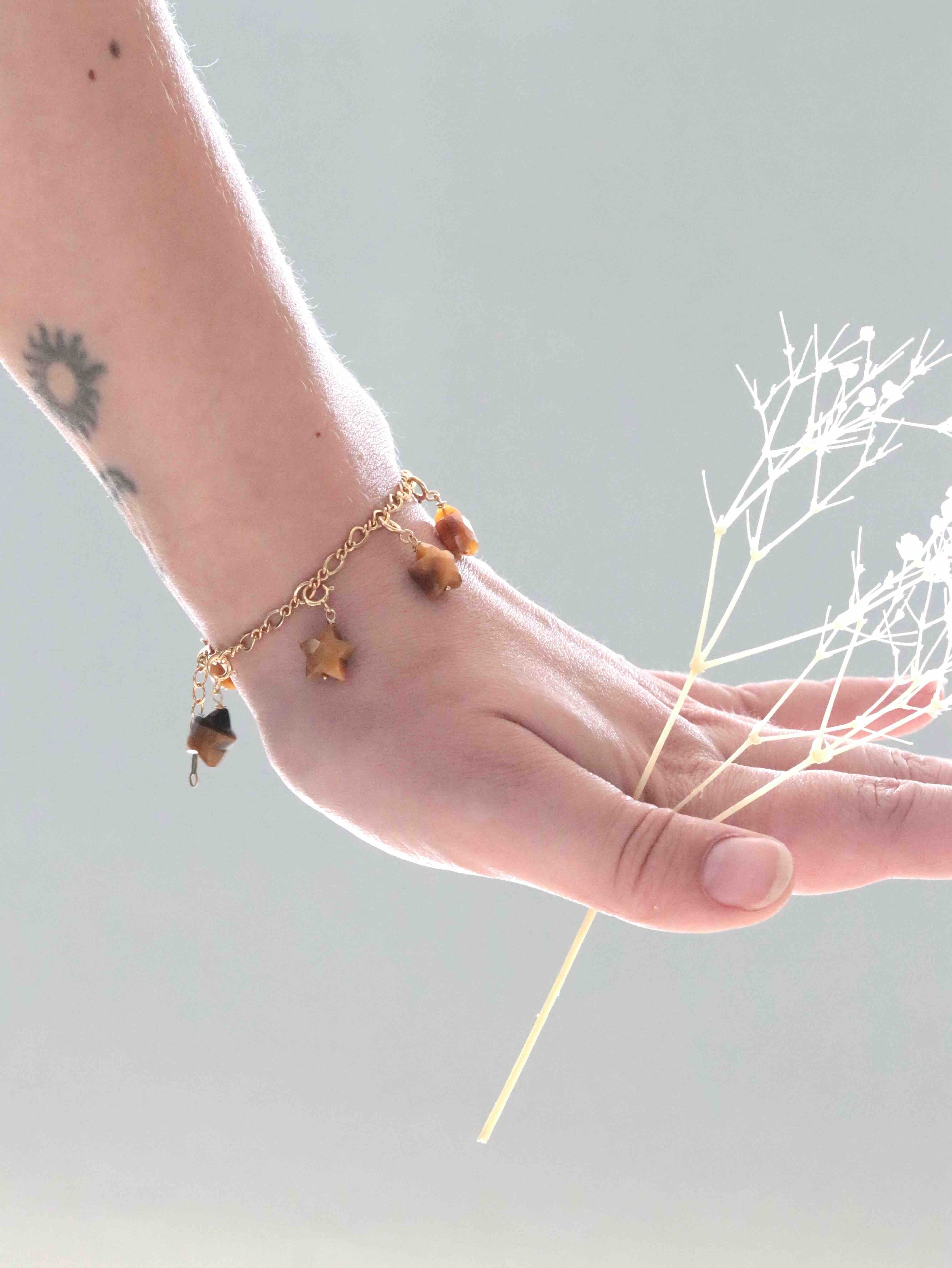 Bracelet à charms en Œil-de-Tigre et Gold-filled 14K porté au poignet — bijou SOLYA avec gemmes étoiles