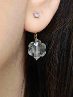 Charm fleur en quartz à tourmaline porté à l’oreille
