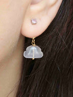Charm nuage en quartz rose porté à l’oreille, suspendu derrière une puce d’oreille. 