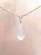 Charm mini Vogel en cristal de roche facetté, avec attache en Gold-filled 14K, suspendu à une chaîne.
