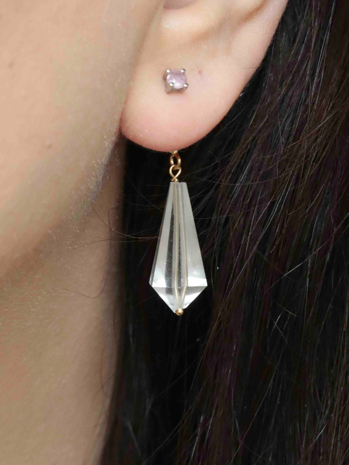 Charm mini Vogel en cristal de roche porté en pendant derrière le lobe de l’oreille.