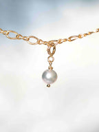 Gros plan sur le Charm Perle grise Gold-filled 14K — Pierre de circulation des énergies SOLYA