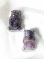 Deux chouettes en améthyste naturelle vues de dos, détails sculptés à la main, nuances violet et mauve