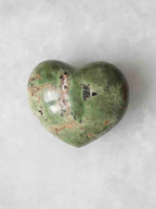 Autre face du cœur en chrysoprase polie, montrant ses motifs verts, bruns et noirs sur un fond clair