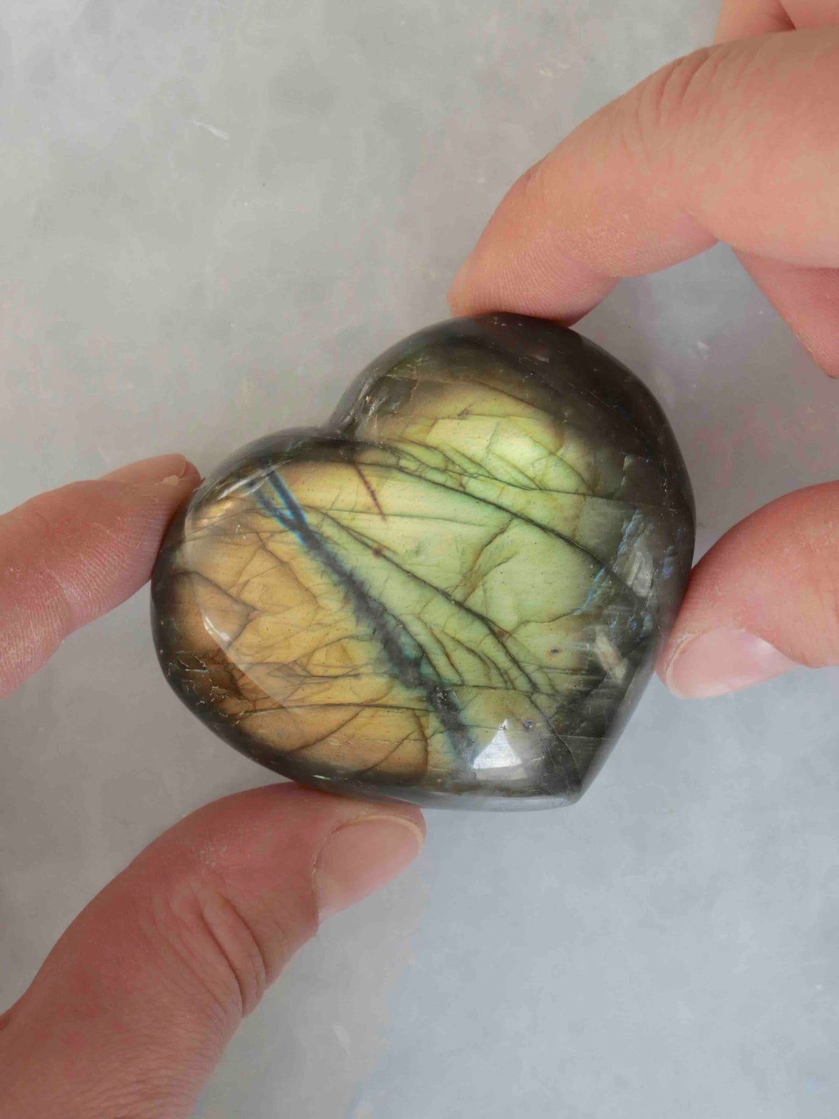 Cœur en labradorite présenté sous un angle qui laisse apparaître ses reflets.