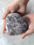 Grand cœur en lépidolite poli tenu en main, inclusions violettes et roses – pierre naturelle pour revenir à l'essentiel – SOLYA Belgique