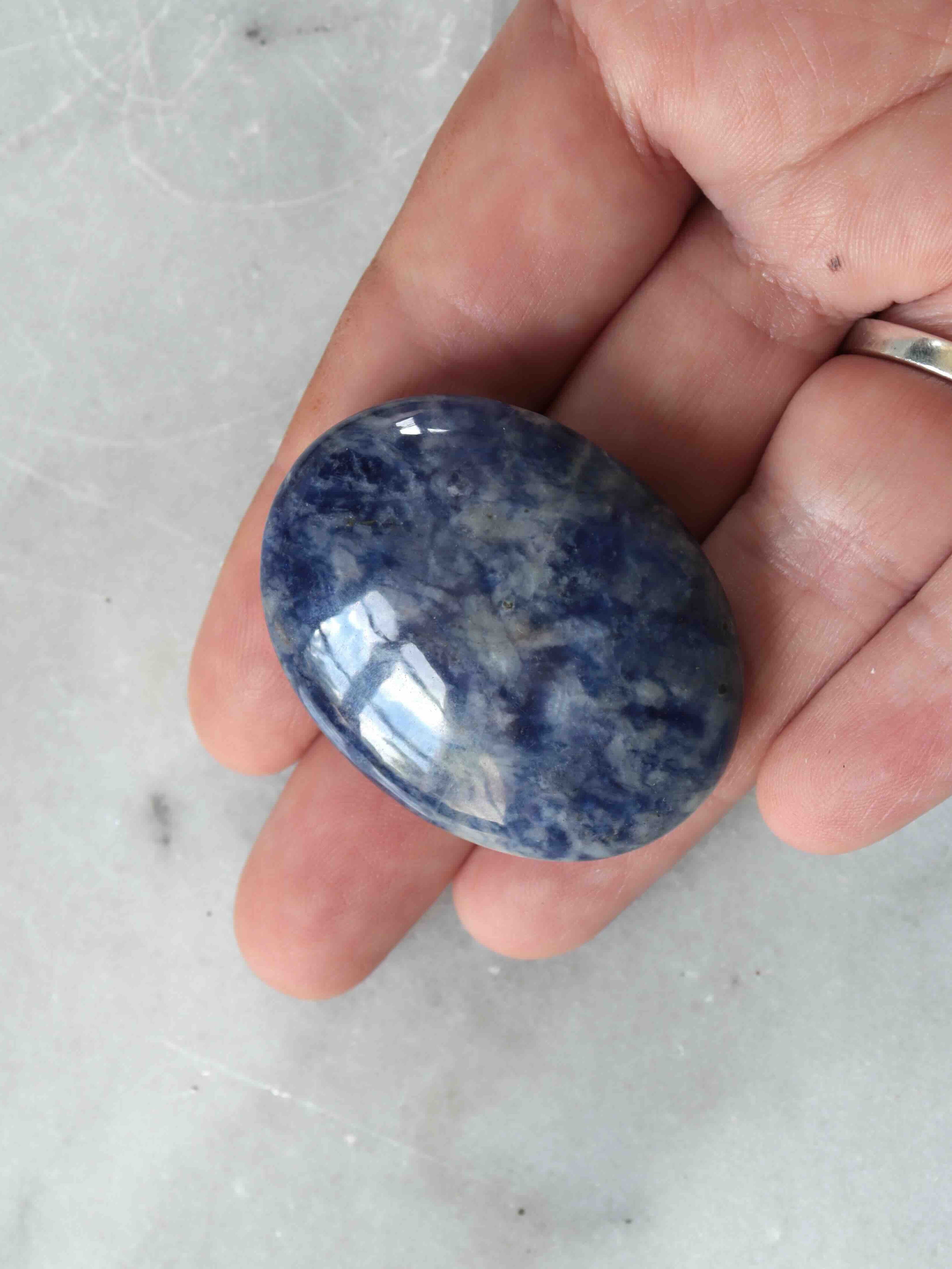 Galet de sodalite poli tenu en main, pierre naturelle bleue veinée de blanc du Brésil, environ 4,5 cm