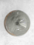 Sphère polie en jaspe polychrome, face à dominante gris-vert avec une marque sombre au centre.