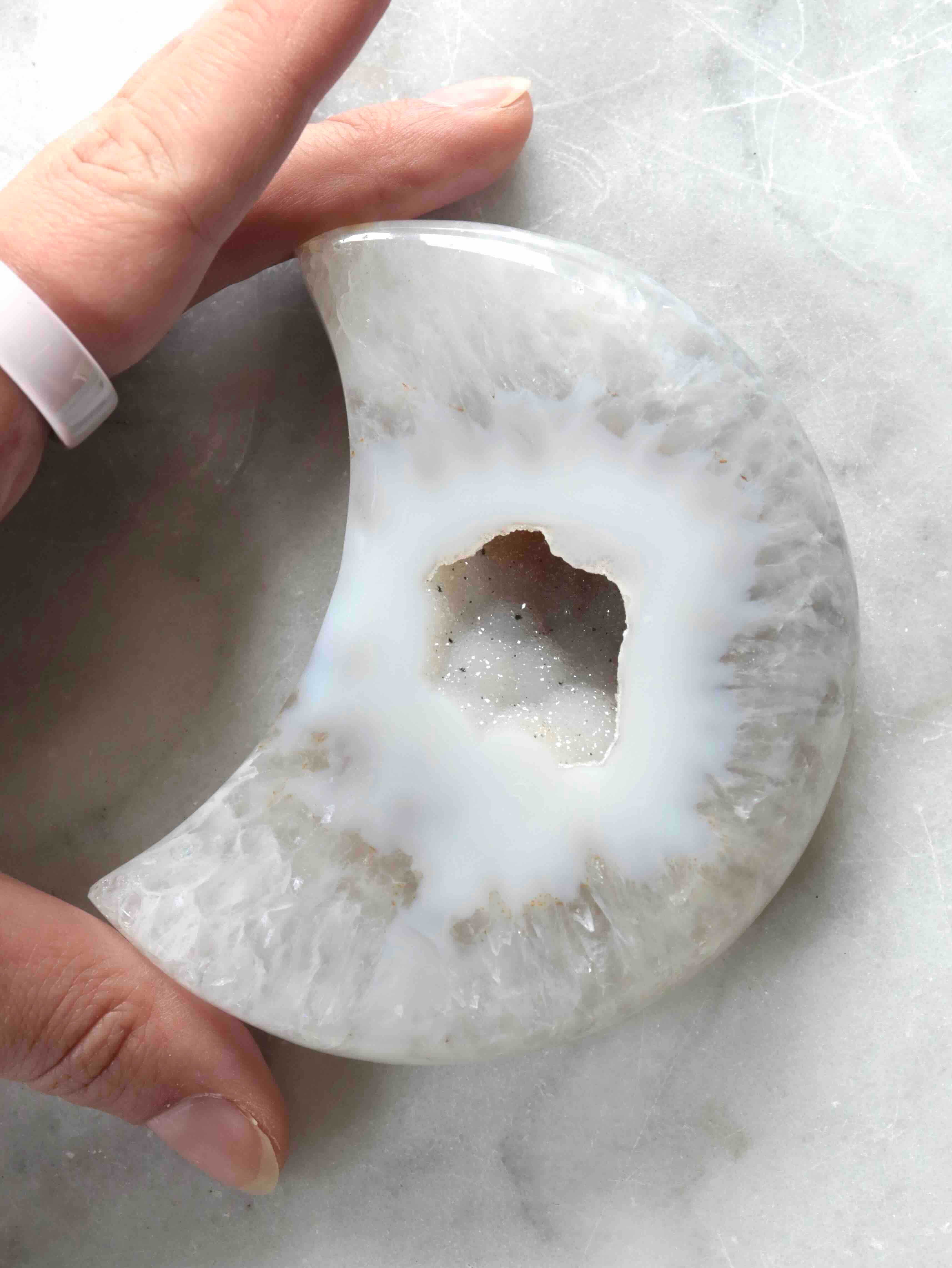 Lune en agate géode tenue dans les mains – taille et cavité cristalline naturelle – pierre naturelle éthique SOLYA Belgique
