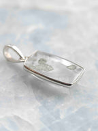 Vue de biais du pendentif en quartz à inclusions de pyrite, montrant la transparence de la pierre et sa fine monture en argent 925.