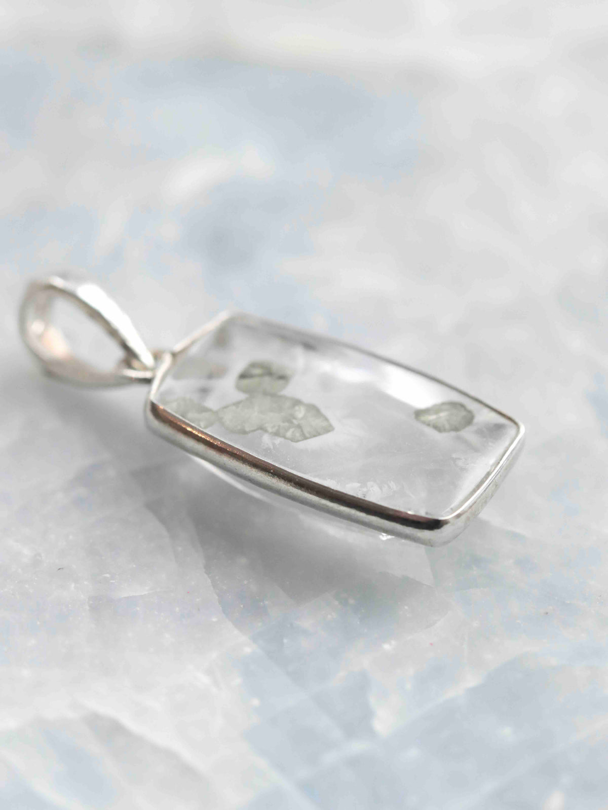 Vue de biais du pendentif en quartz à inclusions de pyrite, montrant la transparence de la pierre et sa fine monture en argent 925.