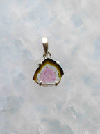 Pendentif en tranche de tourmaline melon d’eau au cœur rose et au pourtour vert foncé, serti à griffes en argent 925, vu de face.