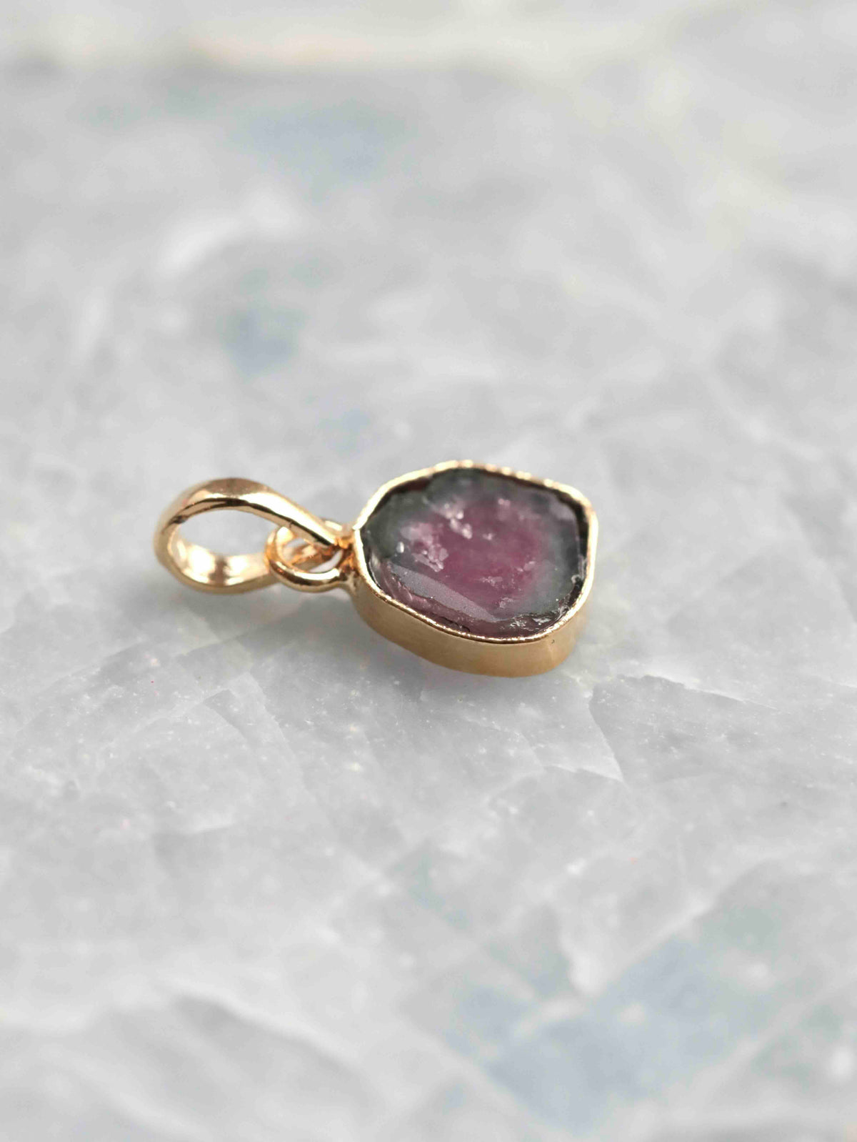 Vue de biais du pendentif en tourmaline melon d’eau rose et verte, montrant l’épaisseur du sertissage et la bélière en argent 925 plaqué or
