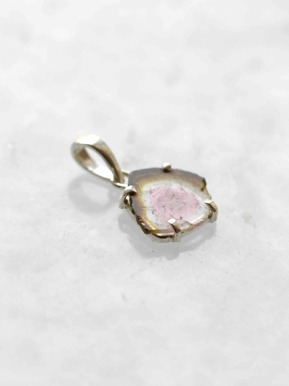 Pendentif en tourmaline melon d’eau et argent 925, vu de biais, montrant la finesse de la tranche et son sertissage à griffes.