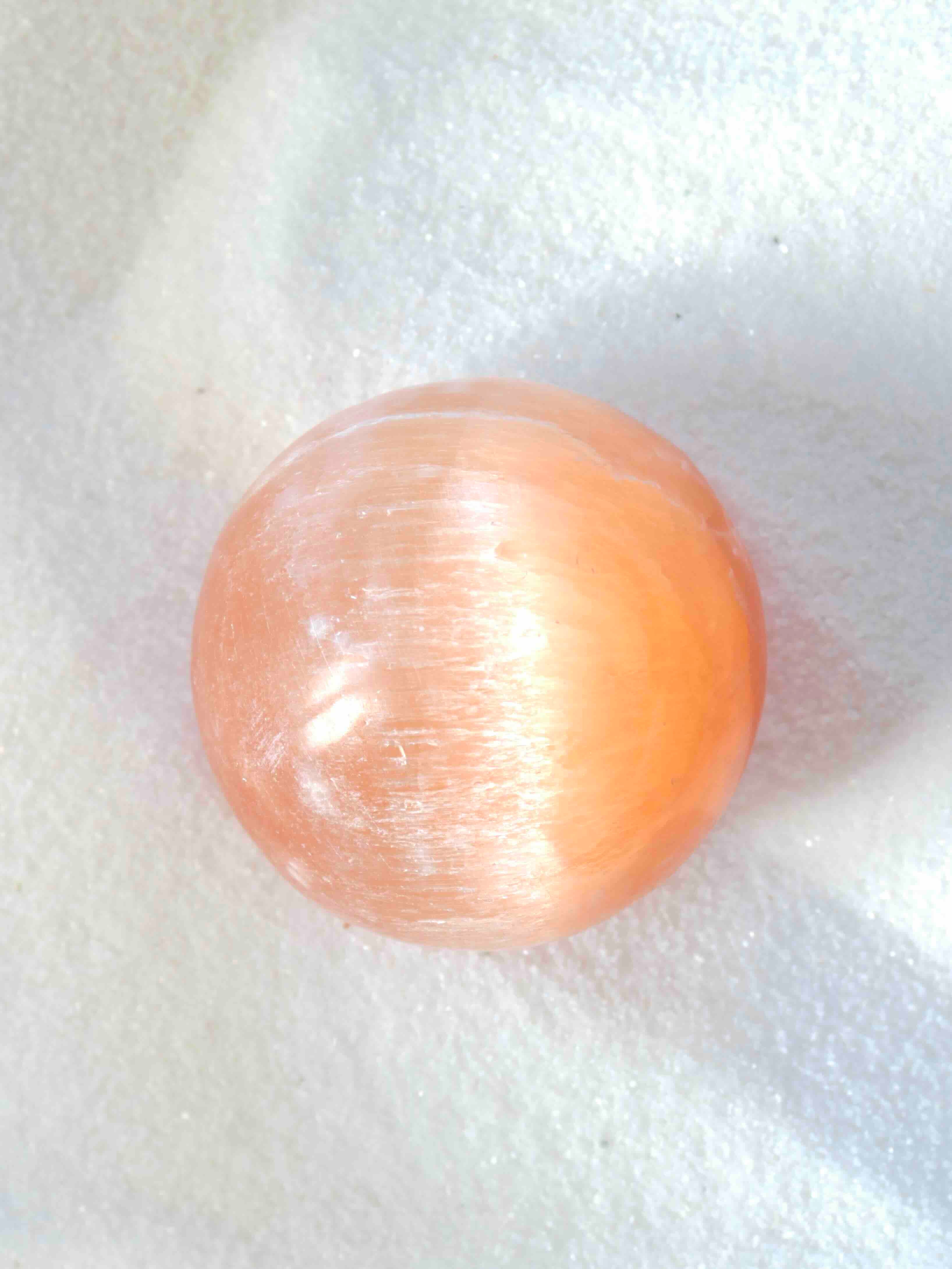 Sphère en Sélénite Orange naturelle – texture fibreuse et reflets soyeux pêche – pierre d'éveil – SOLYA Belgique