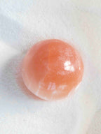 Sphère en Sélénite Orange naturelle – translucide avec reflets internes et base nacrée – connexion à soi – SOLYA Belgique