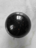 Sphère en tourmaline noire polie vue de dessus – cristal naturel de protection – boutique de pierres éthiques SOLYA