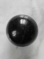 Sphère en tourmaline noire polie vue de dessus – cristal naturel de protection – boutique de pierres éthiques SOLYA