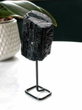 Tourmaline noire brute sur pied métal noir, vue de face – grande pierre de protection du Brésil – SOLYA Belgique